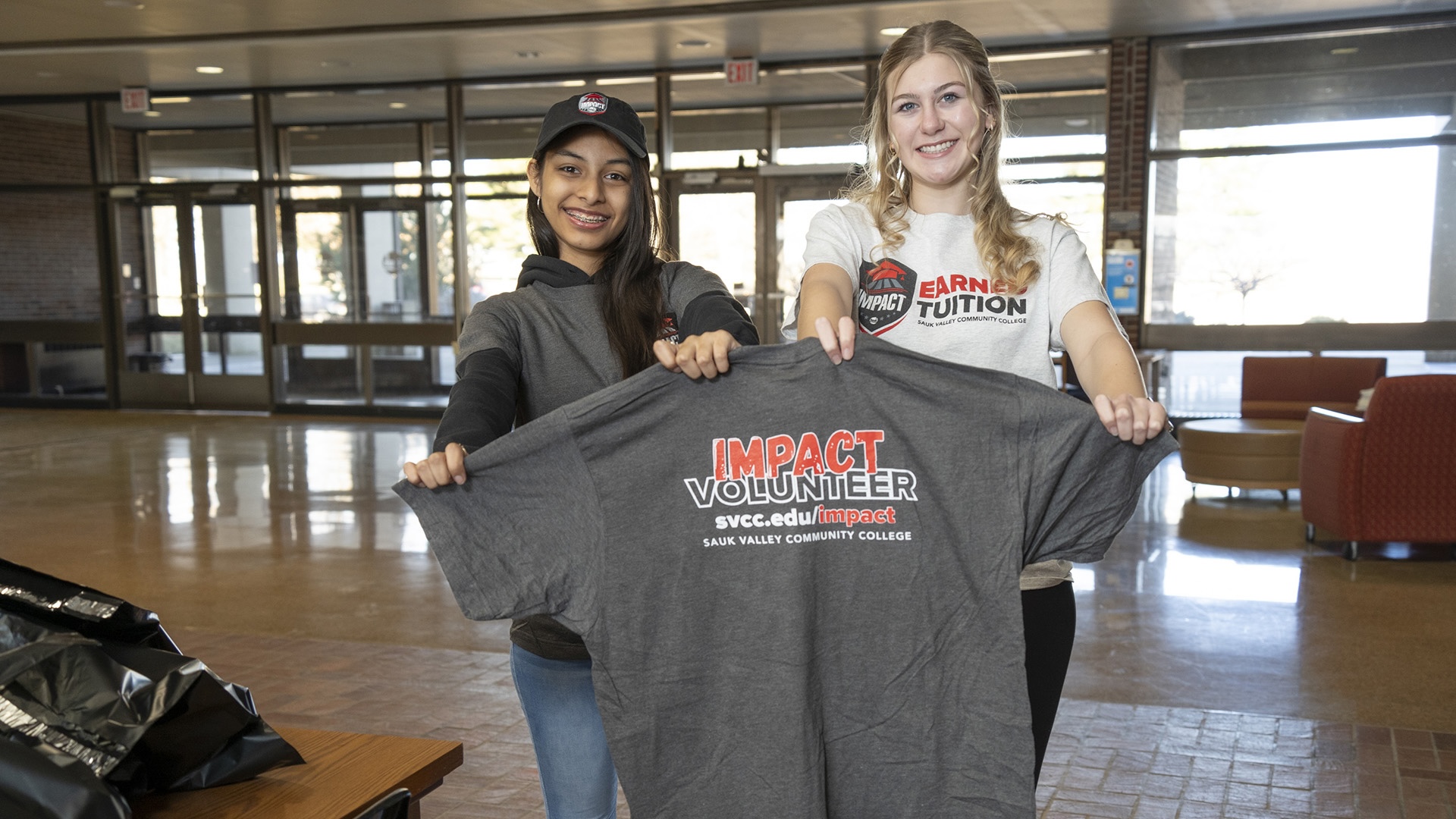 2025 Impact Students holding an Impact Volunteering shirt