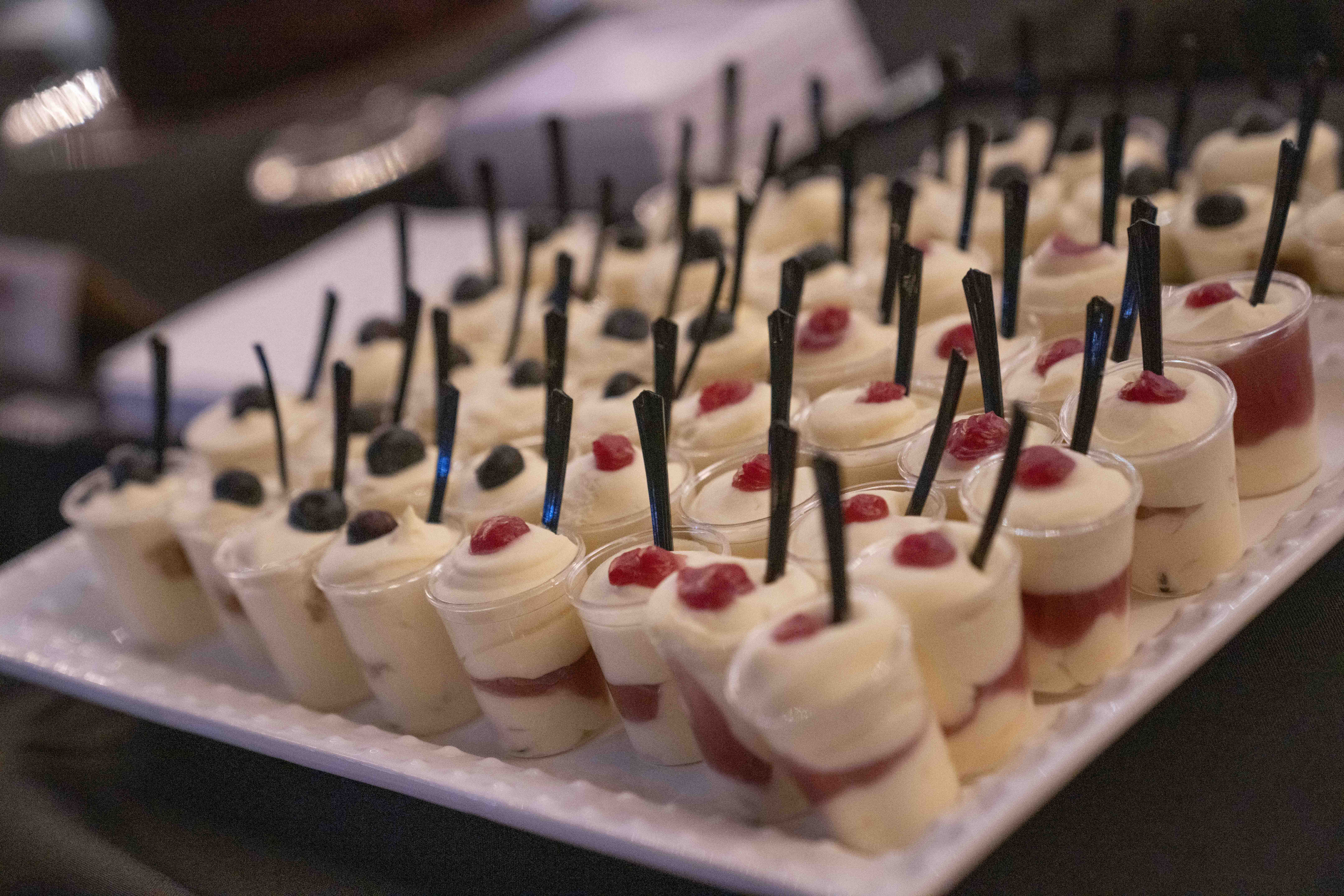 Plate of individual berry parfaits with a spoon in each.