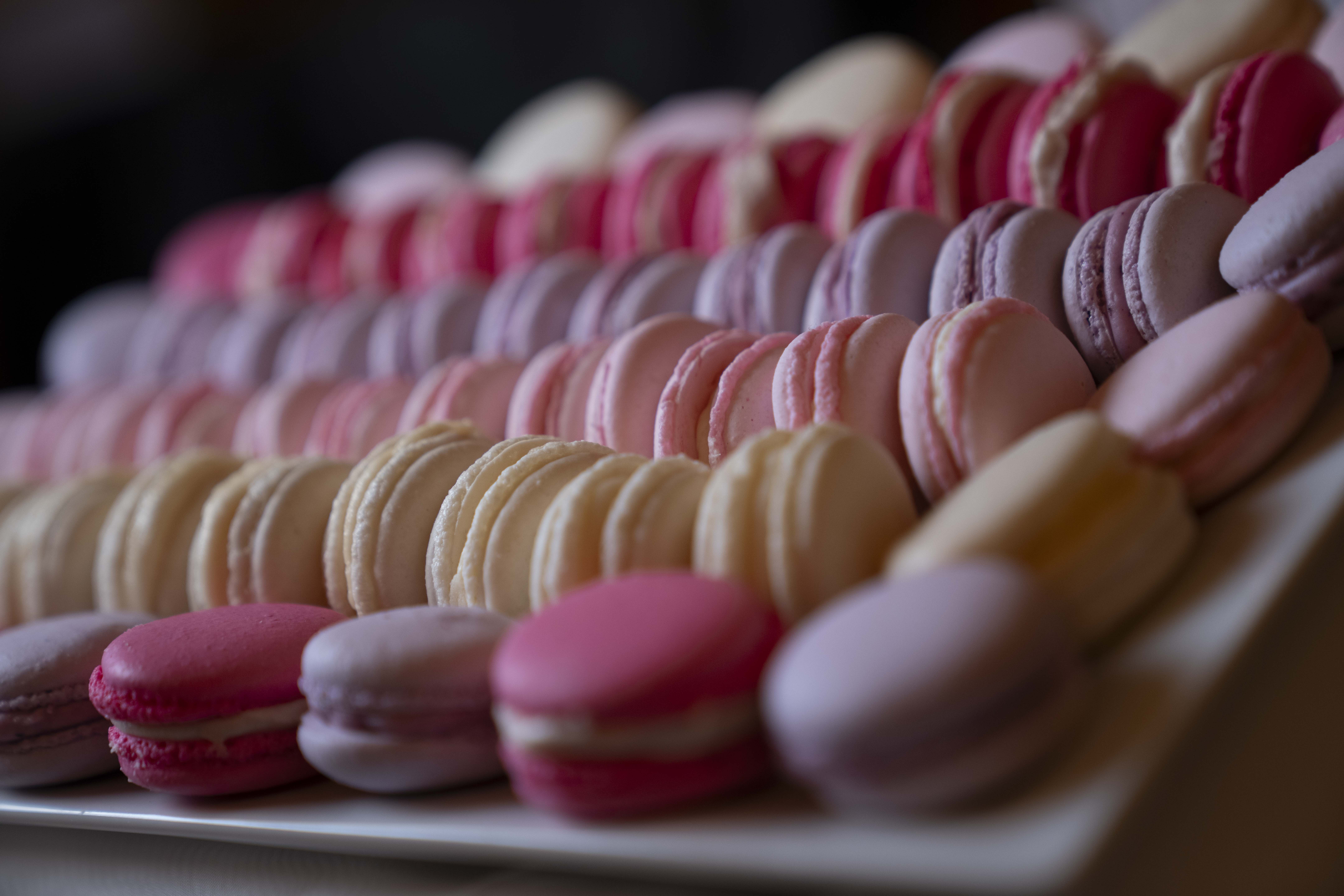 Close-up of a plate of pink, white, and purple macarons.