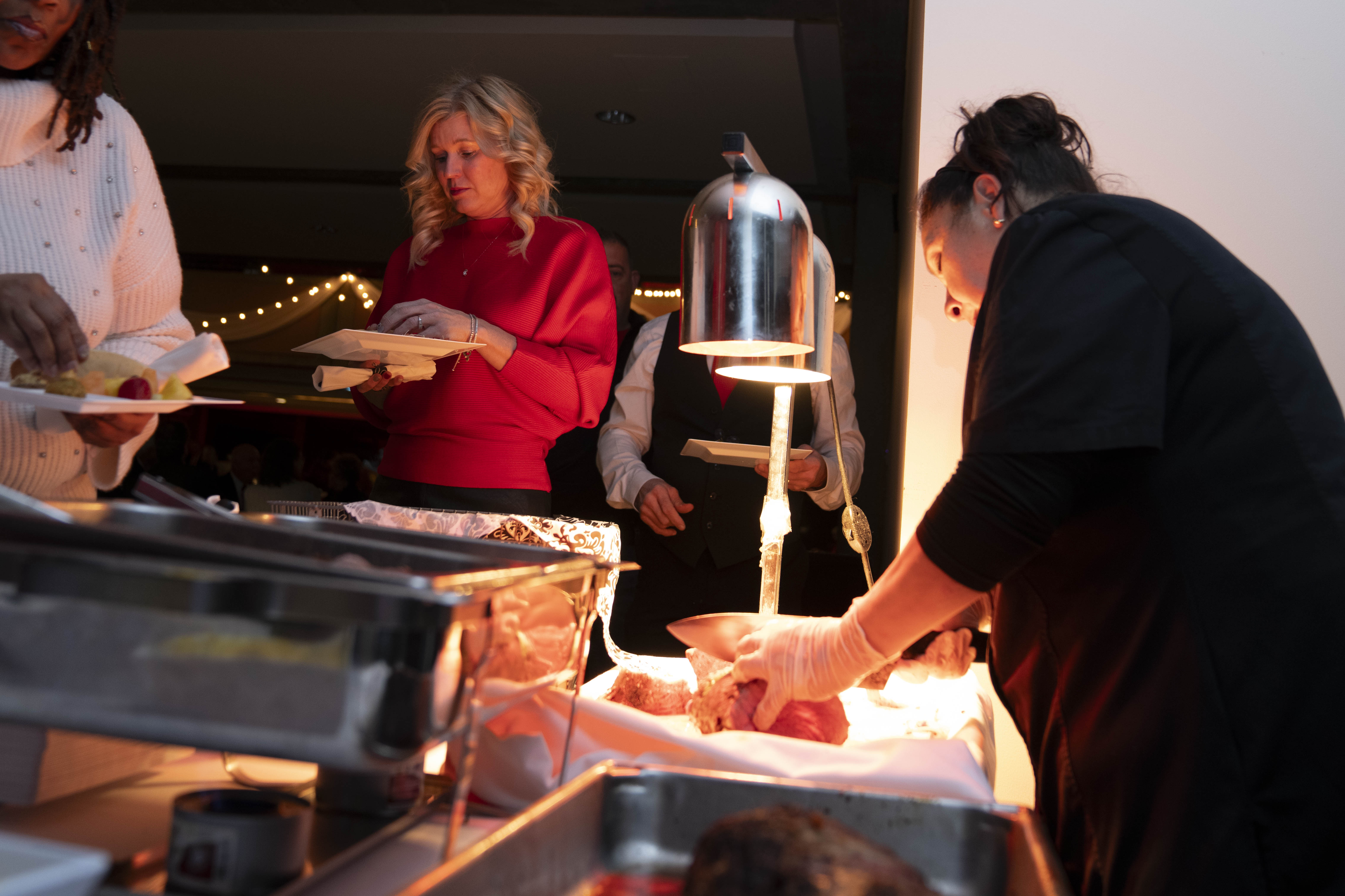 Woman at a meat carving station slicing an item for Chocolate Rendezvous guests.