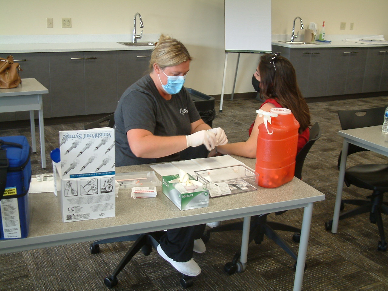 A-nurse-from-the-Lee-County-Health-Department-prepares-to-administer-a-dose-of-the-Moderna-vaccine-at-the-SaukFest-on-campus-vaccine-clinic.JPG