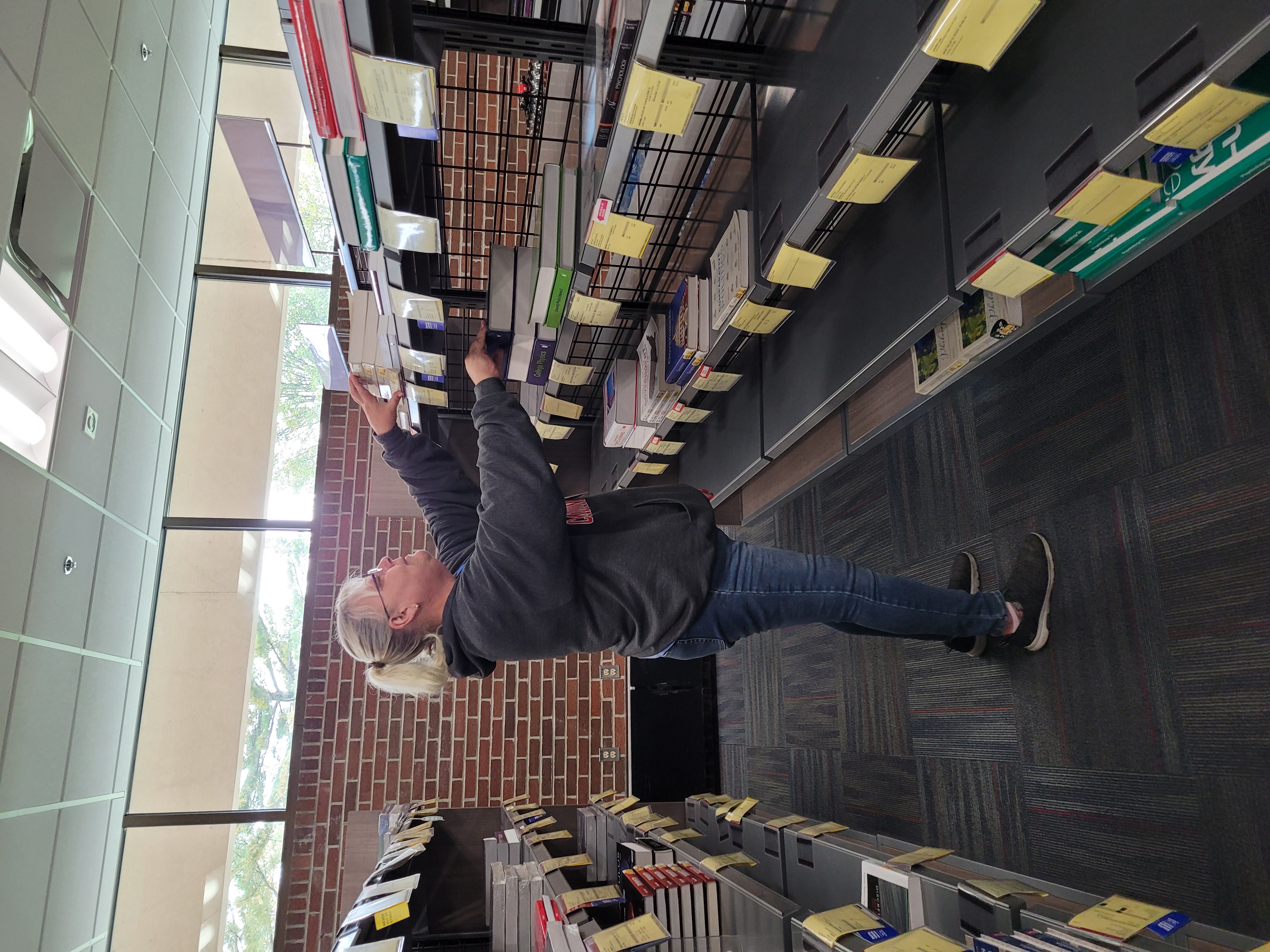 Johnna Dodd, bookstore employee checks textbook inventory