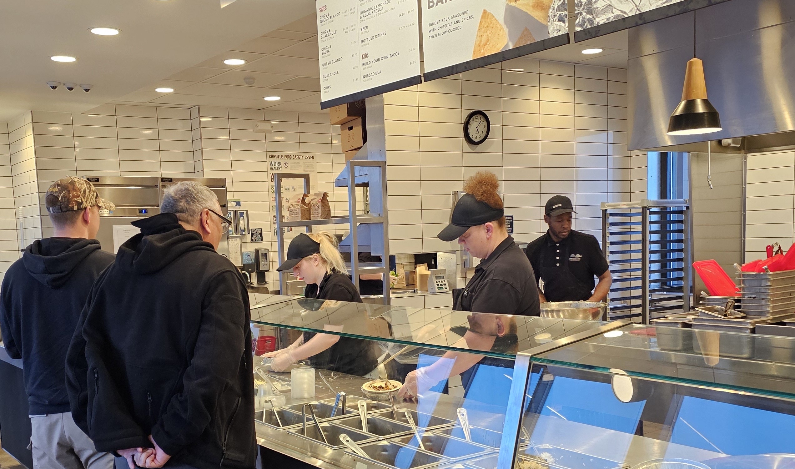 Chipotle staff assisting new customers.