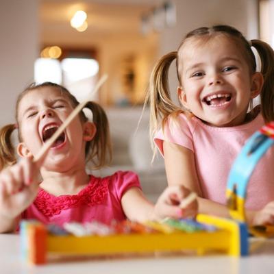 two young girls singing, dancing, and playing instruments